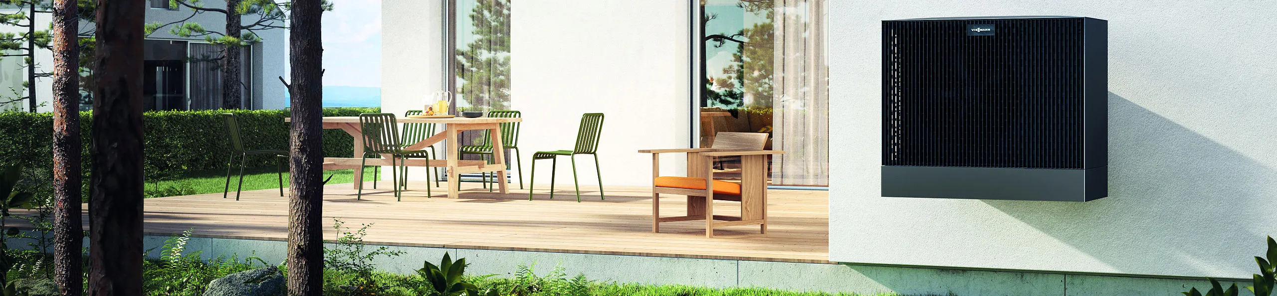 Die wandmontierte Viessmann-Wärmepumpe hängt an einer hellen Fassade direkt neben einer modernen Terrasse mit Sitzmöbeln.