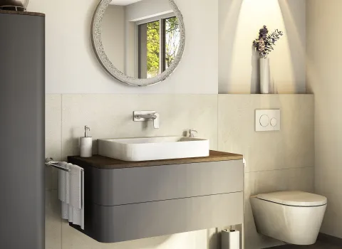 Fotorealistischer Plnungsentwurf eines kompakten Komfort-Badezimmers mit modernem Waschtisch, rundem Spiegel und schwebender Toilette. Dezente Dekoration sorgt für gemütliche Atmosphäre.