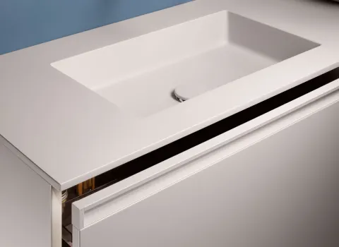 Detail eines Stocco Waschtisches mit integriertem Becken, schmaler Griffleiste und leicht geöffnetem Schubfach.
