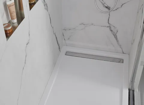 Bodengleiche Duschwanne aus Acryl des Herstellers HSK mit Ablaufrinne aus poliertem Edelstahl.