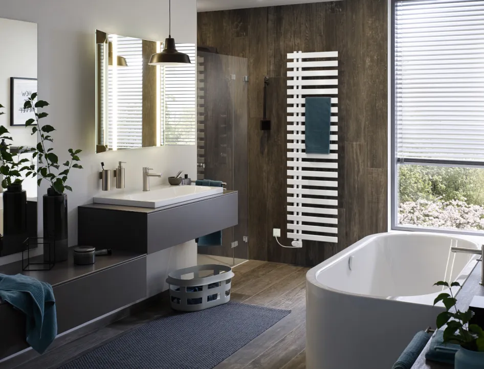 Ein modernes Badezimmer mit einem freistehenden weißen Badewanne und einem großen Fenster, das viel Licht hereinlässt. 